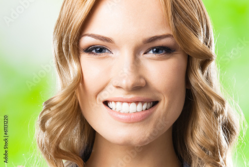 Photo: Happy woman with thumbs up gesture, outdoor Happy woman with thumbs up gesture, outdoor