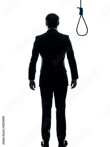 Photo: business man standing in front of hangman noose silhouette rear business man standing in front of hangman noose silhouette rear