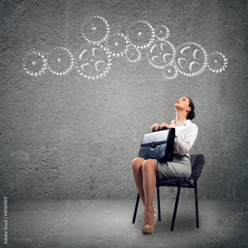Photo: young business woman looking at the mechanism young business woman looking at the mechanism