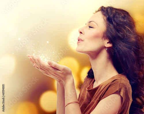 Photo: Young Woman Blowing Magic Dust with Stars from her Hands Young Woman Blowing Magic Dust with Stars from her Hands