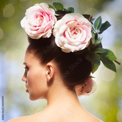 Photo: Rear view portrait of the woman with pink flowers in hairs Rear view portrait of the woman with pink flowers in hairs