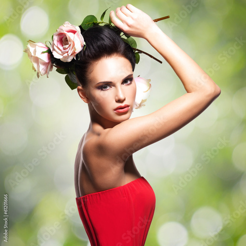 Photo: Portrait of beautiful young woman with flowers in hair. Portrait of beautiful young woman with flowers in hair.