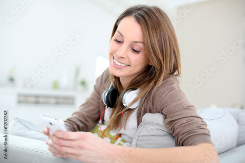 Photo: Smiling young woman websurfing with smartphone Smiling young woman websurfing with smartphone
