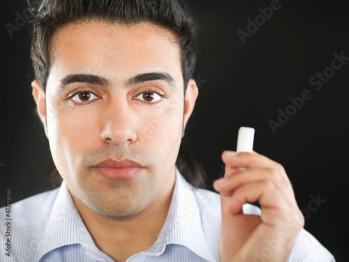 Photo: Young man writing something on glass board. Young man writing something on glass board.