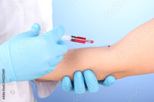 Photo: Nurse taking a blood sample, close up Nurse taking a blood sample, close up