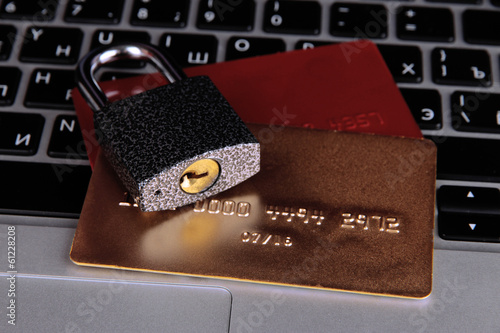 Photo: Credit cards and lock on keyboard close up Credit cards and lock on keyboard close up