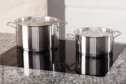 Photo: Two metal pots on induction hob Two metal pots on induction hob