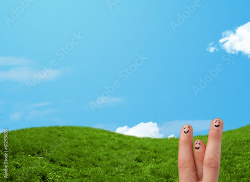 Photo: Cheerful finger smileys with landscape scenery at the background Cheerful finger smileys with landscape scenery at the background