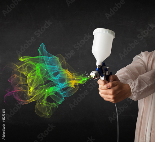 Photo: Painter working with airbrush and paints colorful paint Painter working with airbrush and paints colorful paint