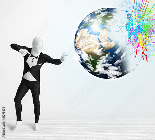Photo: Funny man in body suit looking at colorful splatter earth Funny man in body suit looking at colorful splatter earth