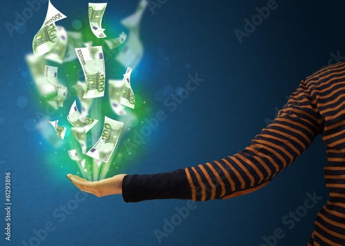 Photo: Glowing money in the hand of a woman Glowing money in the hand of a woman