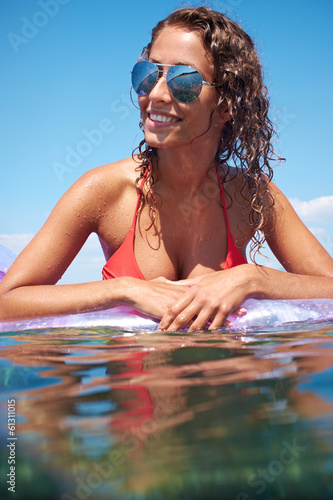 Photo: very happy woman on pink air bed in sea very happy woman on pink air bed in sea