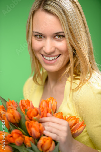 Photo: Smiling woman hold spring flowers orange tulip Smiling woman hold spring flowers orange tulip