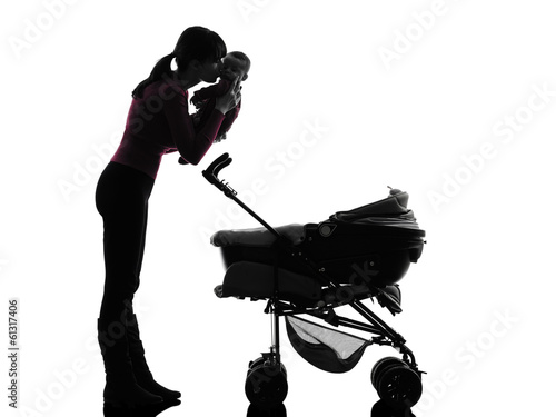 Photo: woman prams holding kissing baby silhouette woman prams holding kissing baby silhouette