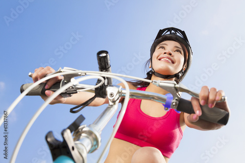 Photo: female biker starting to ride with blue sky background female biker starting to ride with blue sky background