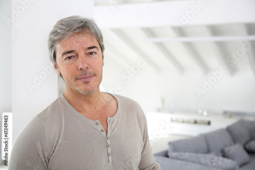 Photo: Mature handsome man standing in modern house Mature handsome man standing in modern house