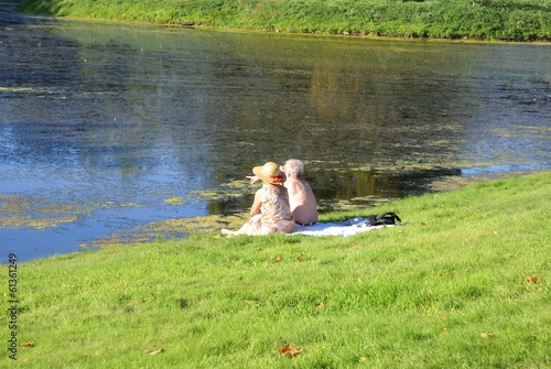 Photo: elderly couple sitting relaxing at lakeside elderly couple sitting relaxing at lakeside