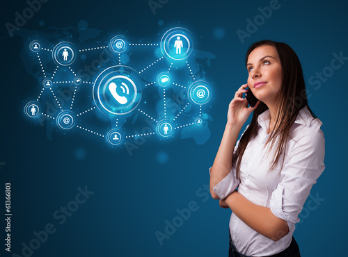 Photo: Pretty girl making phone call with social network icons Pretty girl making phone call with social network icons