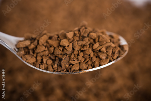 Photo: Spoon of coffee at coffee background Spoon of coffee at coffee background