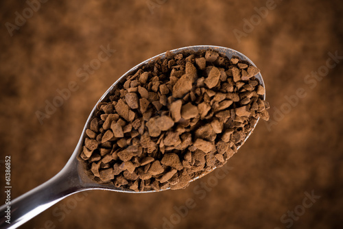 Photo: Spoon of coffee at coffee background Spoon of coffee at coffee background