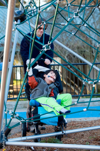 Photo: Father with disabled boy at the playground Father with disabled boy at the playground