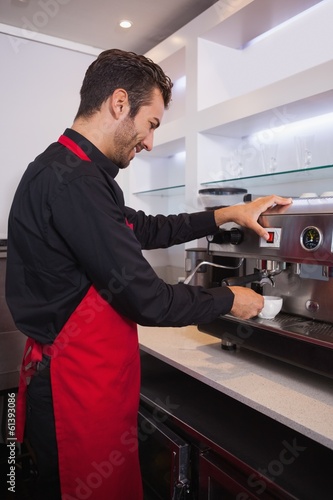 Photo: Smiling attractive barista making cup of coffee Smiling attractive barista making cup of coffee