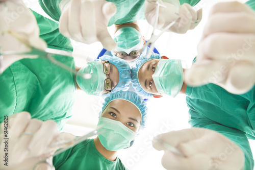 Photo: Surgeons and assistant operating with surgical instruments Surgeons and assistant operating with surgical instruments