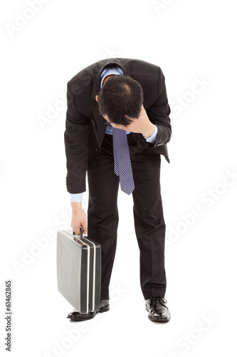 Photo: afflictive businessman stoop and hold his head afflictive businessman stoop and hold his head