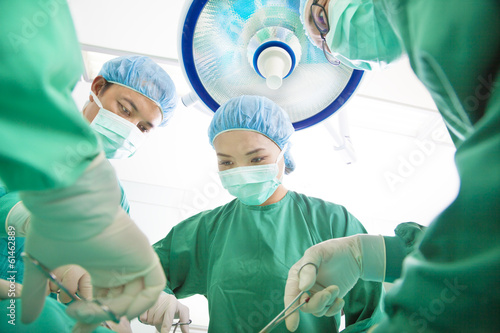 Photo: Surgeon team working together in a surgical room Surgeon team working together in a surgical room
