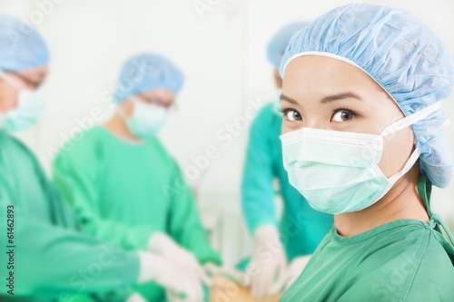 Photo: Woman surgeon working with team in a surgical room Woman surgeon working with team in a surgical room