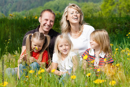 Photo: Glückliche Familie im Frühling auf Wiese Glückliche Familie im Frühling auf Wiese