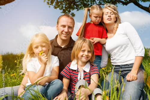 Photo: Glückliche Familie im Frühling auf Wiese Glückliche Familie im Frühling auf Wiese
