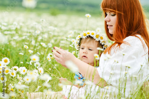 Photo: fun of little girl and redhead young woman in daisy field fun of little girl and redhead young woman in daisy field
