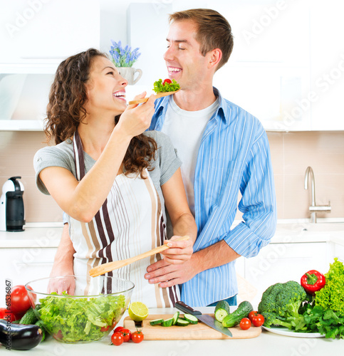 Photo: Happy Couple Cooking Together. Dieting. Healthy Food Happy Couple Cooking Together. Dieting. Healthy Food