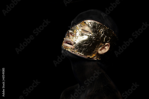 Photo: Fiction. Imagination. Futuristic Creature in Mystic Mask. Gilt Fiction. Imagination. Futuristic Creature in Mystic Mask. Gilt