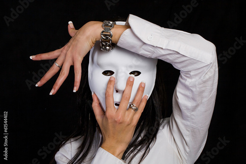 Photo: Beautiful woman hiding behind a mask Beautiful woman hiding behind a mask