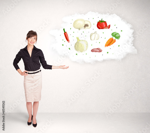 Photo: Young girl presenting nutritional cloud with vegetables Young girl presenting nutritional cloud with vegetables