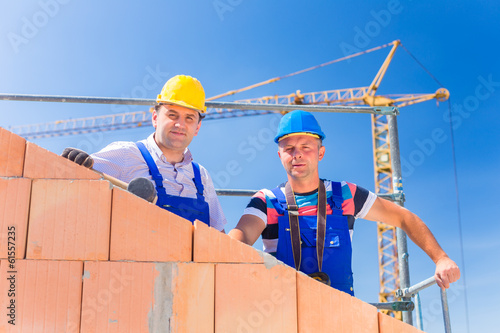 Photo: Bauarbeiter auf Baustelle mit Kran Bauarbeiter auf Baustelle mit Kran