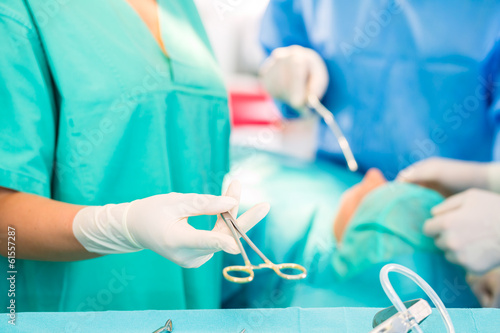 Photo: Chirurgen operieren in OP-Saal an Patienten Chirurgen operieren in OP-Saal an Patienten