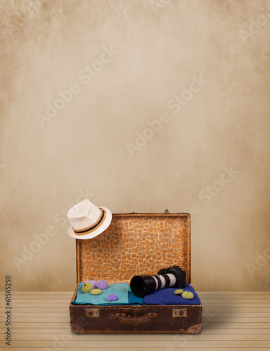 Photo: Retro tourist luggage with colorful clothes and copyspace Retro tourist luggage with colorful clothes and copyspace