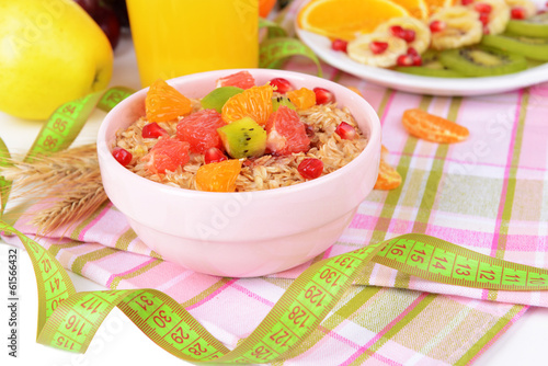Photo: Delicious oatmeal with fruit in bowl on table close-up Delicious oatmeal with fruit in bowl on table close-up