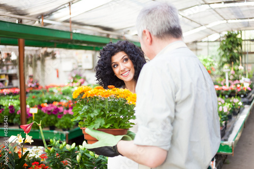 Photo: Man selling flowers in a greenhouse Man selling flowers in a greenhouse