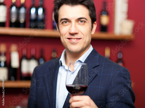 Photo: Handsome man holding a glass of wine Handsome man holding a glass of wine