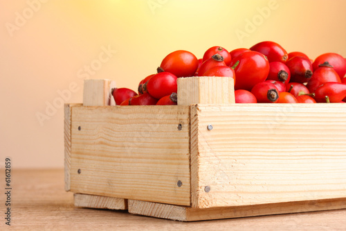Photo: ripe briar in wooden box on wooden table on brown background ripe briar in wooden box on wooden table on brown background