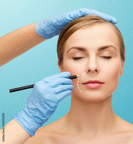 Photo: woman face and beautician hands with pencil woman face and beautician hands with pencil