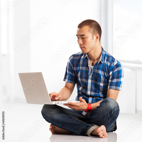 Photo: Young Asian man surfing the net Young Asian man surfing the net