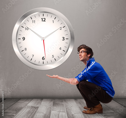 Photo: Attractive boy holding a huge clock Attractive boy holding a huge clock