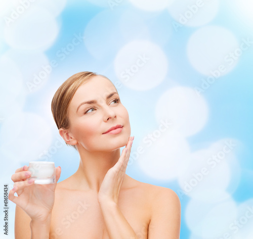 Photo: woman applying cream on her skin woman applying cream on her skin