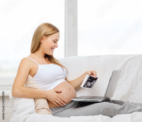 Photo: smiling pregnant woman with laptop computer smiling pregnant woman with laptop computer