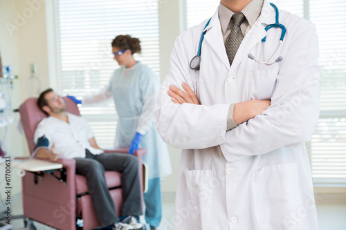 Photo: Doctor Standing Arms Crossed In Chemo Room Doctor Standing Arms Crossed In Chemo Room